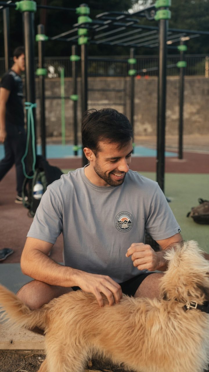 Ismael Cabo sonriendo con un perro en el parque de calistenia